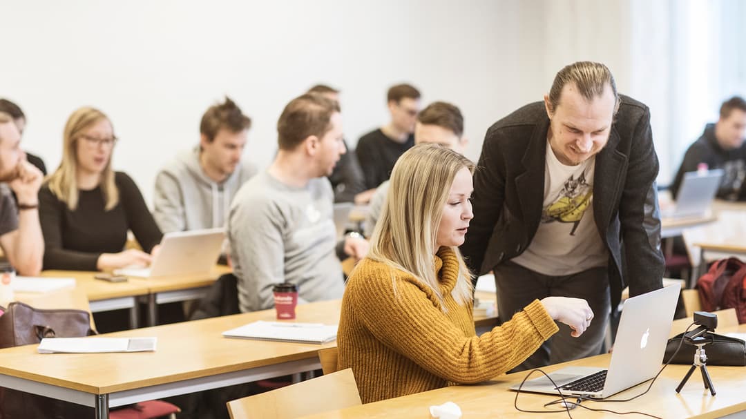 Klassrum – lärare hjälper student