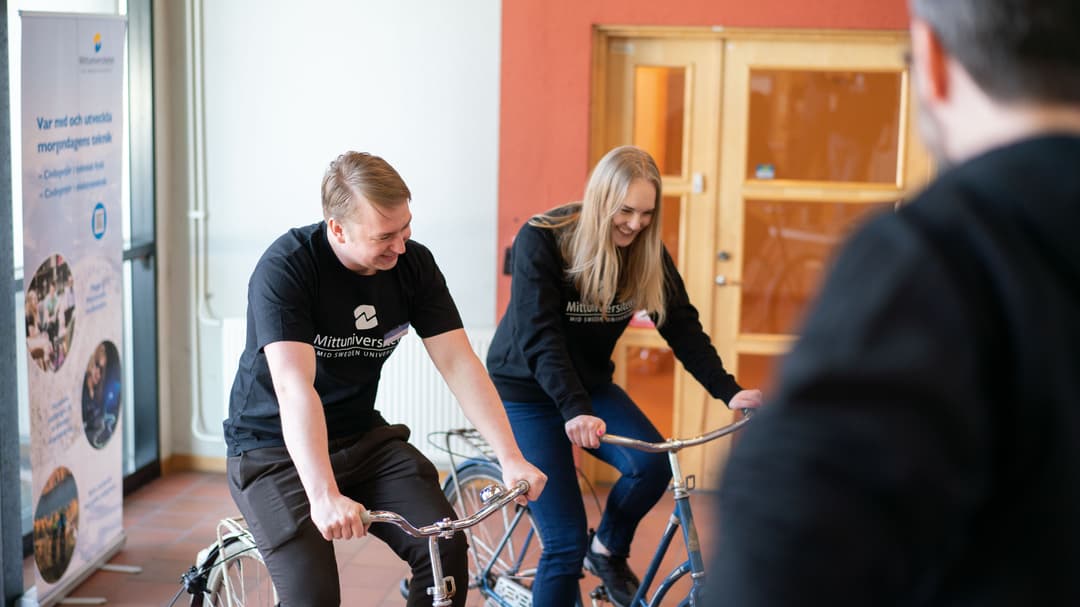 Två studenter som utmanar varandra i en energigivande duell - på varsin cykel.