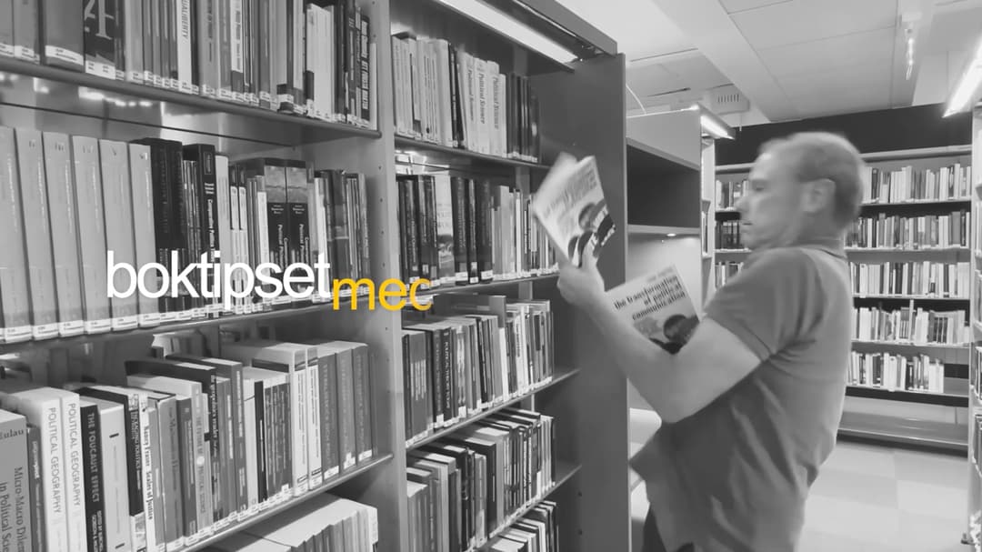 man i bibliotek som kämpar att hålla i flera böcker