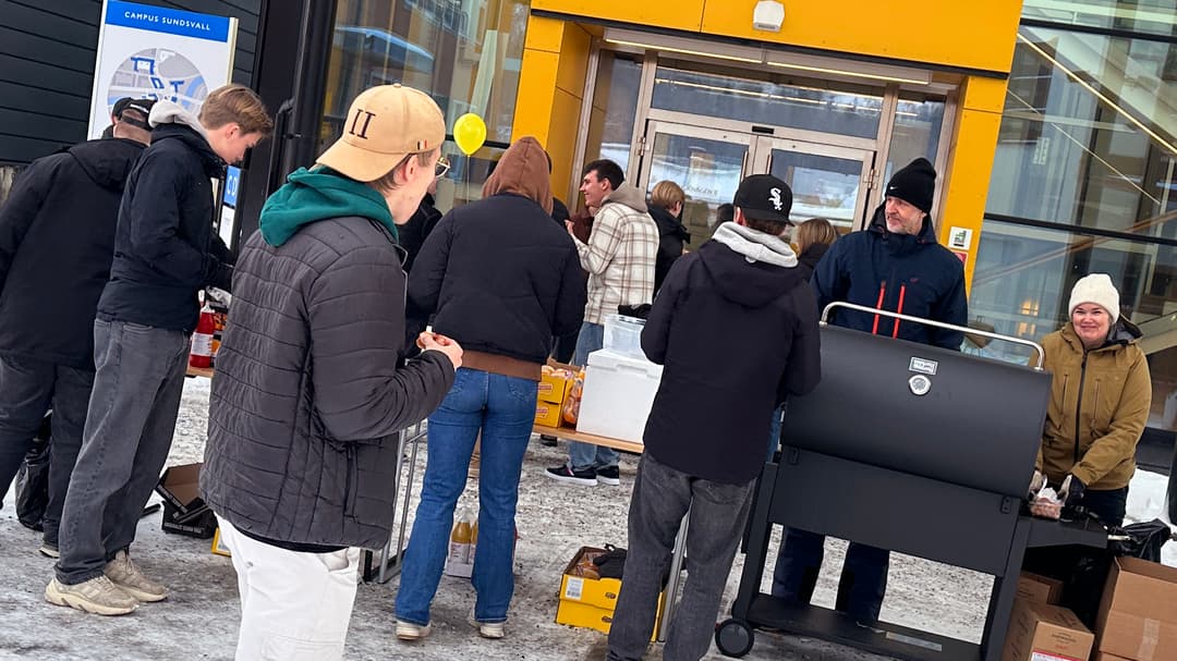 En grupp människor som står runt en grill