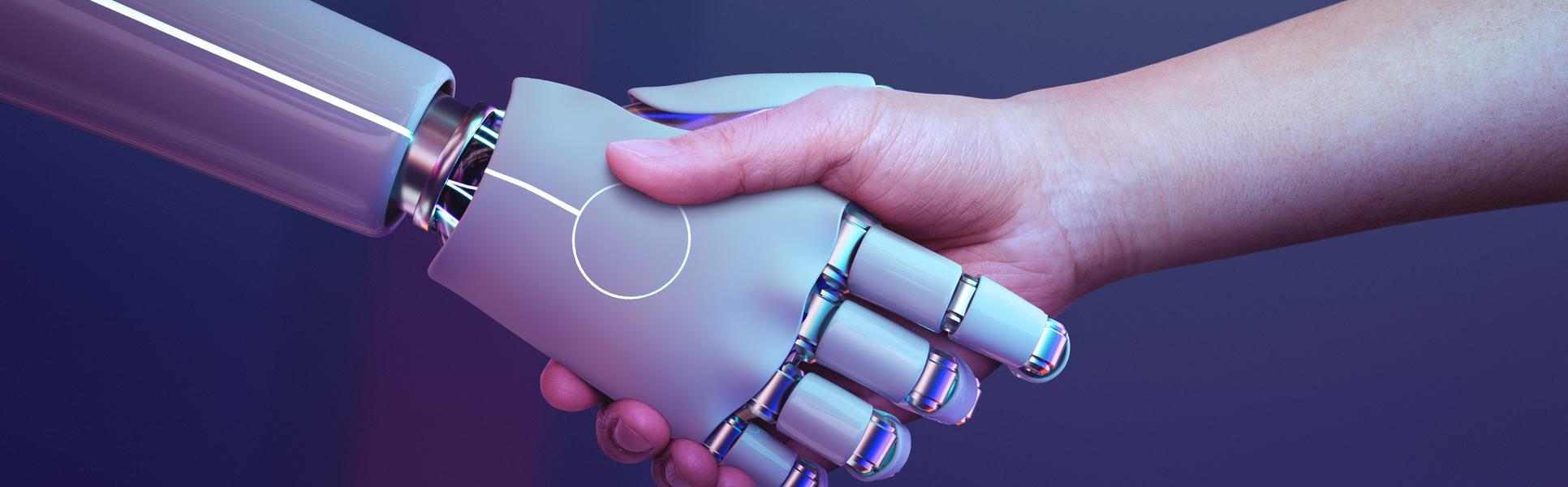 En robothand och en mänsklig hand som hälsar i ett handtag.
