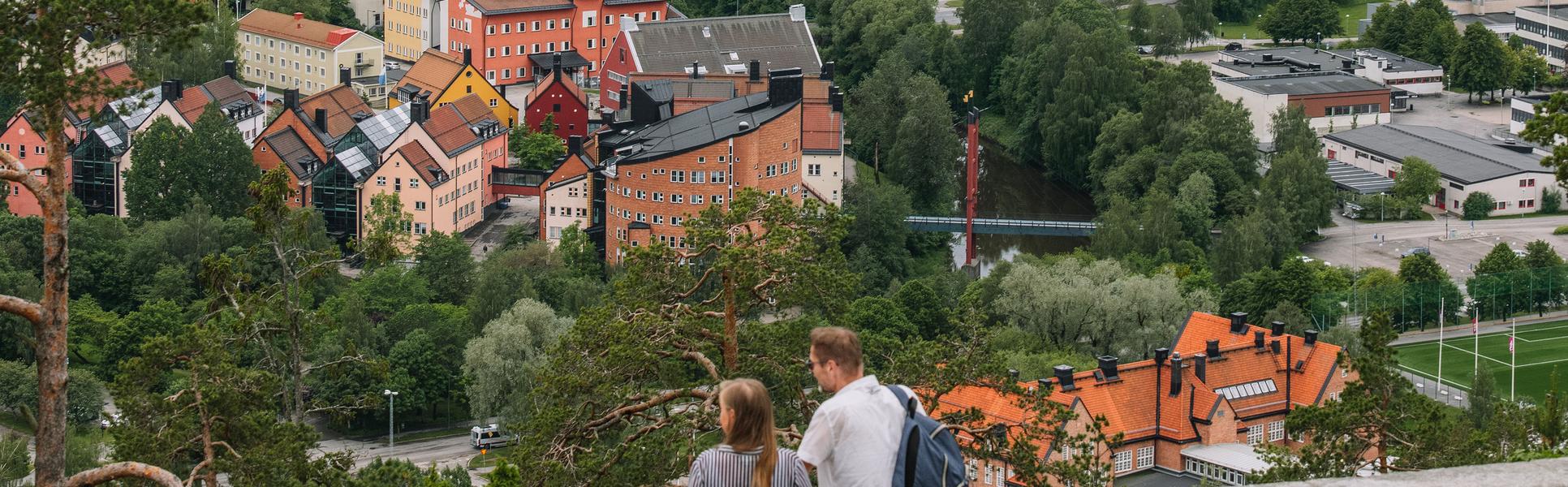 Two people looking at the view over Campus Sundsvall from the north mountain.
