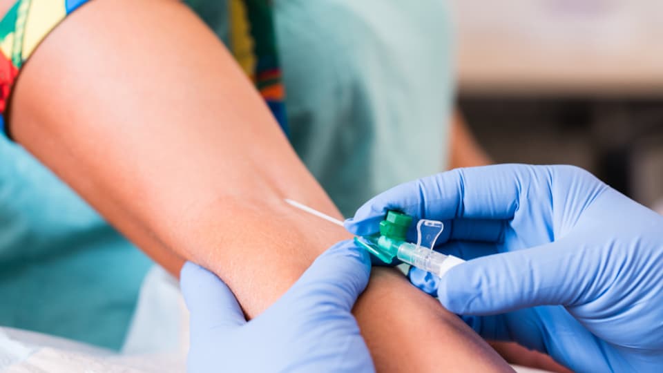 Nål sticks i underarm för att ta blodprov