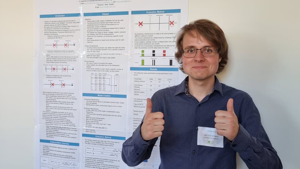 a person is standing in front of a sign and is showing his thumbs up