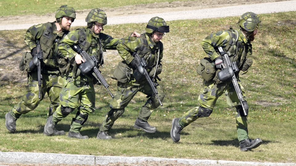Militärer springer över ett fält
