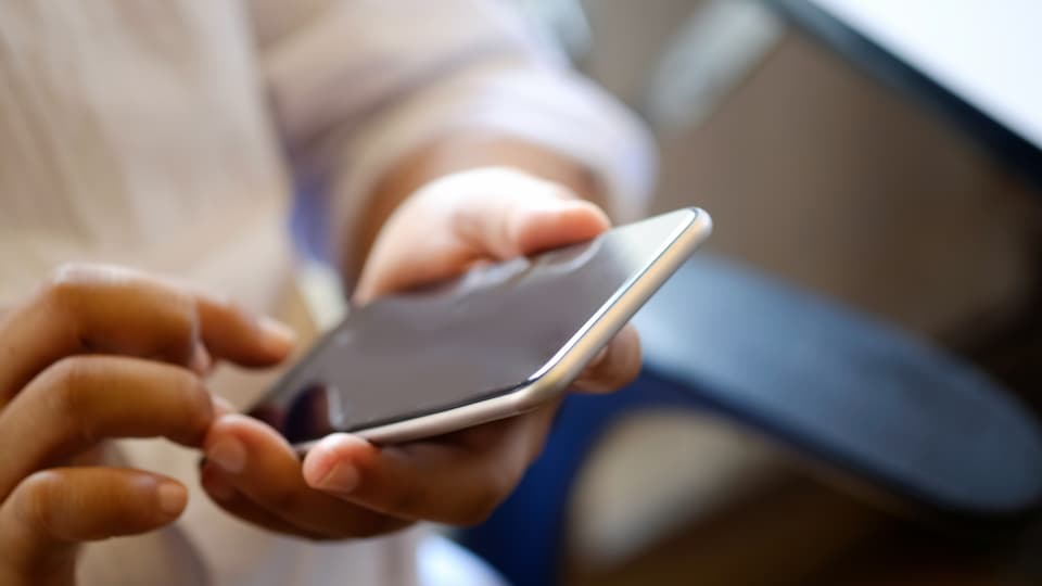 Närbild man håller mobiltelefon