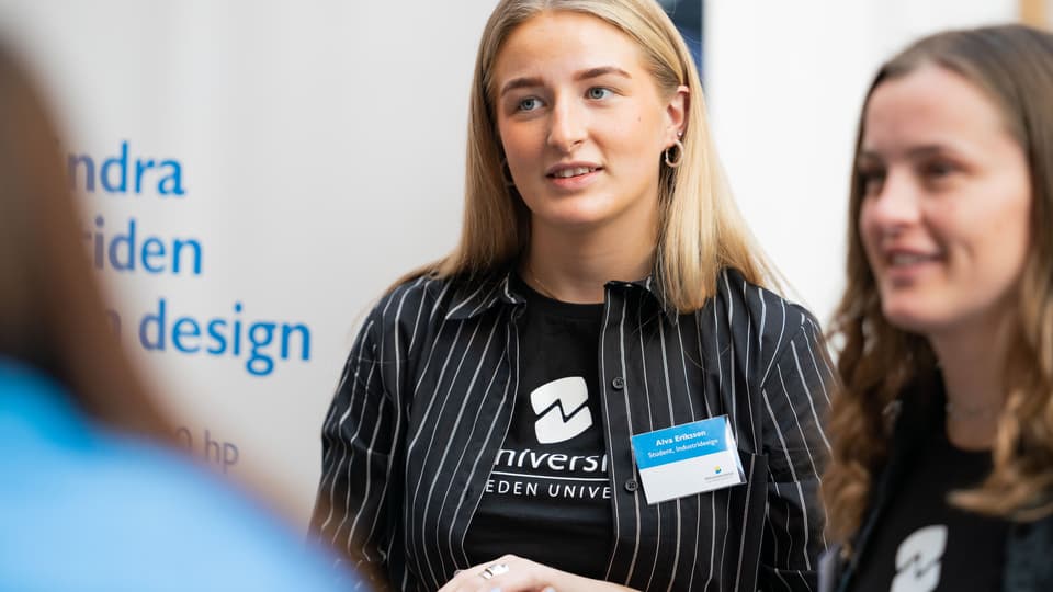 Två studentambassadörer som jobbar i monter. 