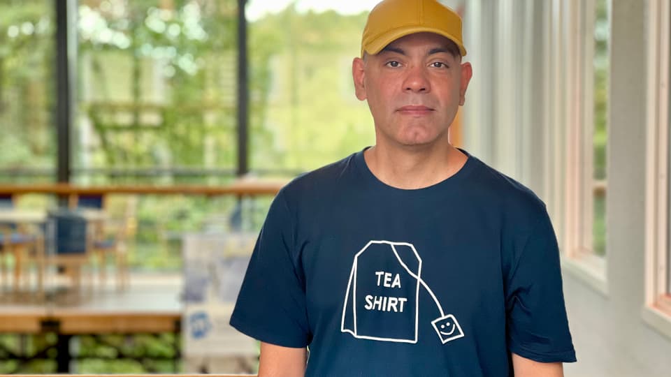 A man with a tshirt and a yellow hat