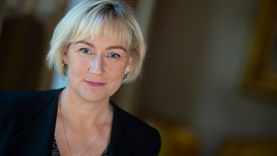 Porträtt av blond kvinna i svart kavaj
