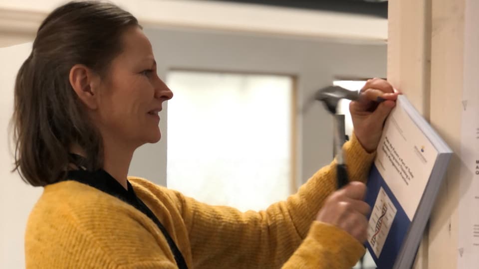 En kvinna spikar upp en avhandling