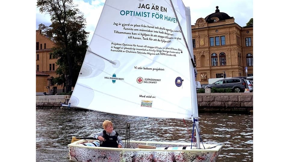 Optimistjolle gjord av plast med skräpa-inte-ned-budskap på seglet