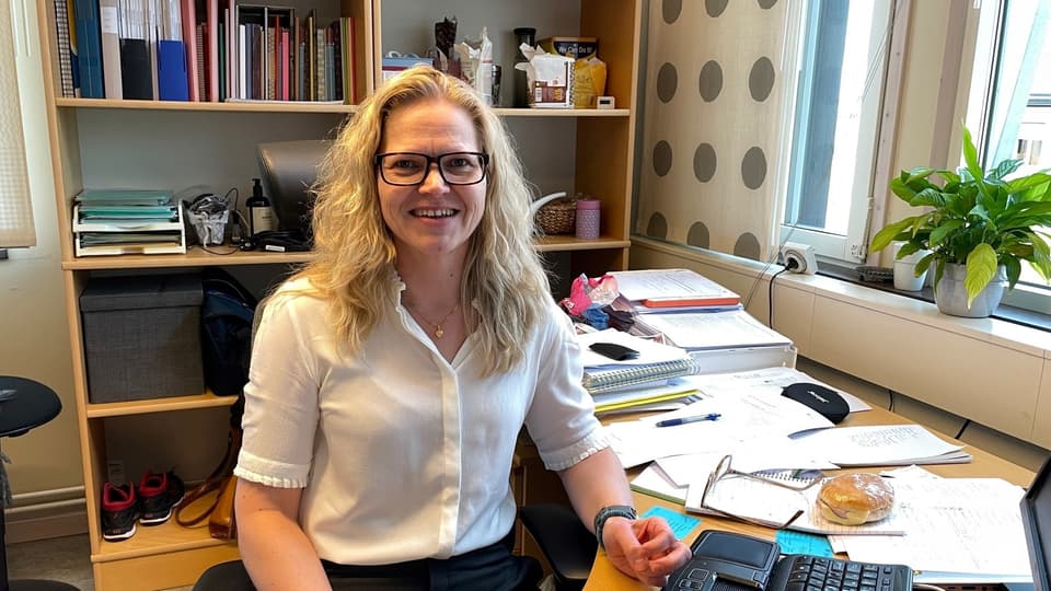 Karin Olsson sitter vid sitt skrivbord.