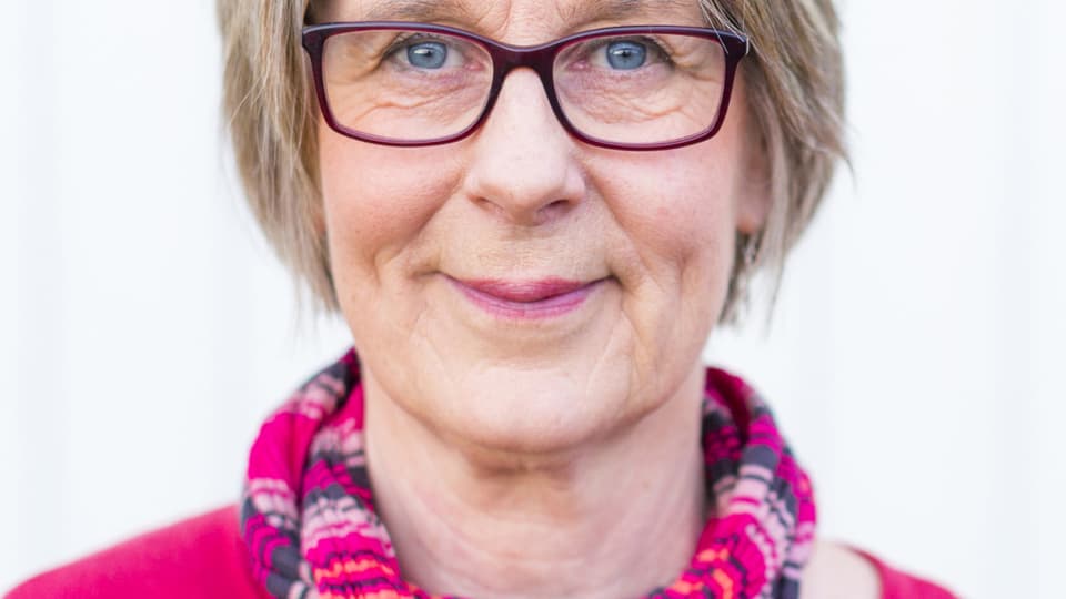 Lena Runius, en kvinna med rosa glasögon och blus