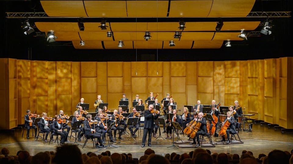 Orkester spelar på scen med publik