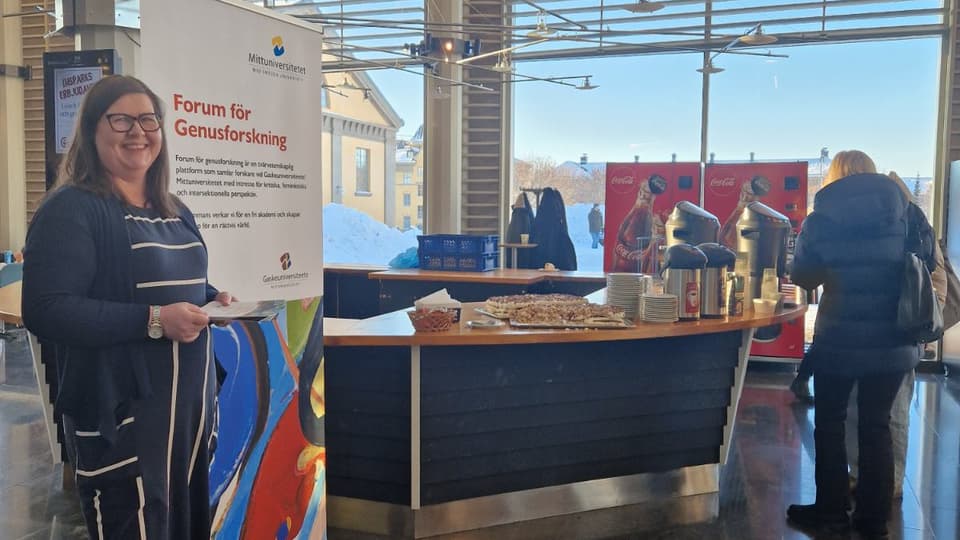 Ett bord med tårta samt en roll-up på campus i Östersund