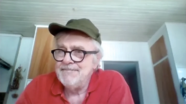 Man med keps sitter i ett kök