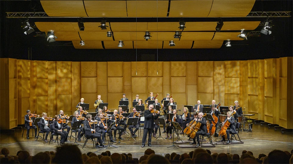 Orkester spelar på scen med publik