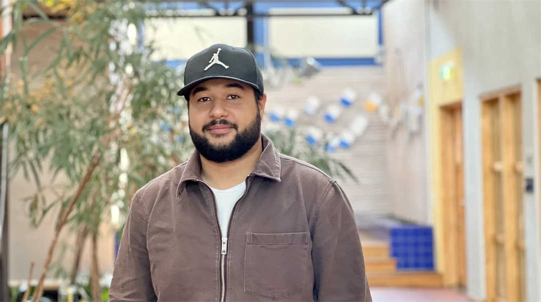 En man med skägg och keps och brun tröja