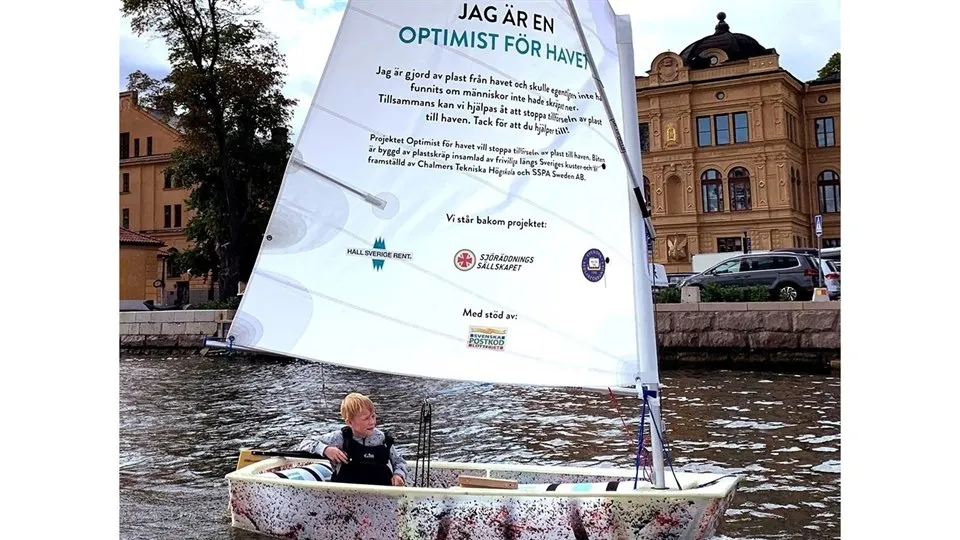 Optimistjolle gjord av plast med skräpa-inte-ned-budskap på seglet