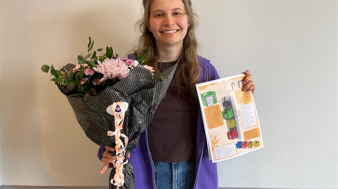 En gad tjej i lila jacka och jeans som håller en bukett med blommor och ett papper med en illustration på