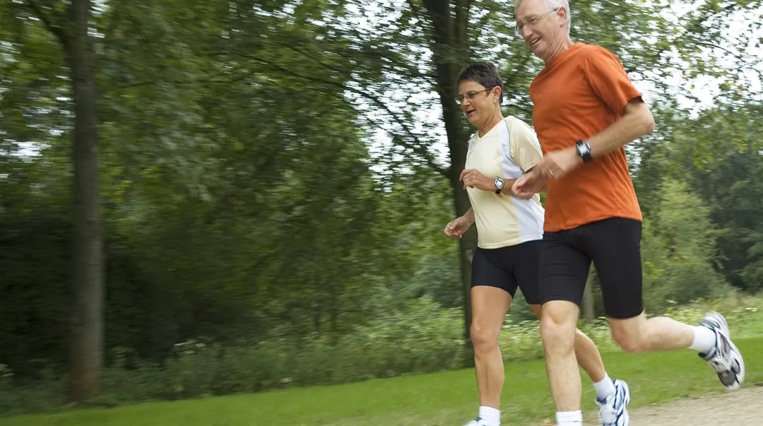 man och kvinna joggar i naturen