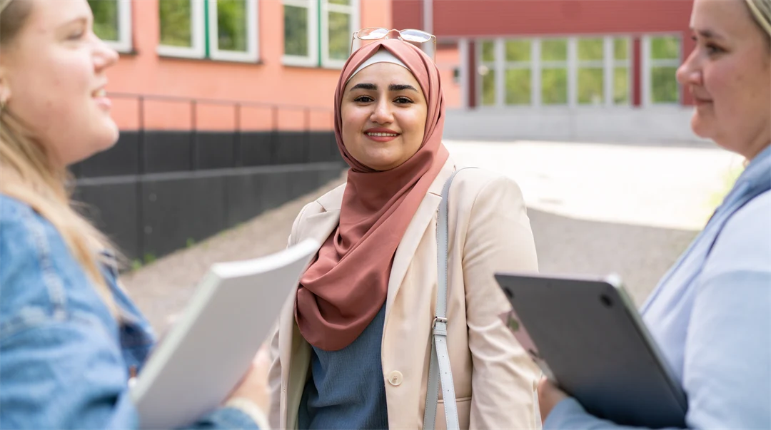 A group of students standing and talking to each other outside the campus.