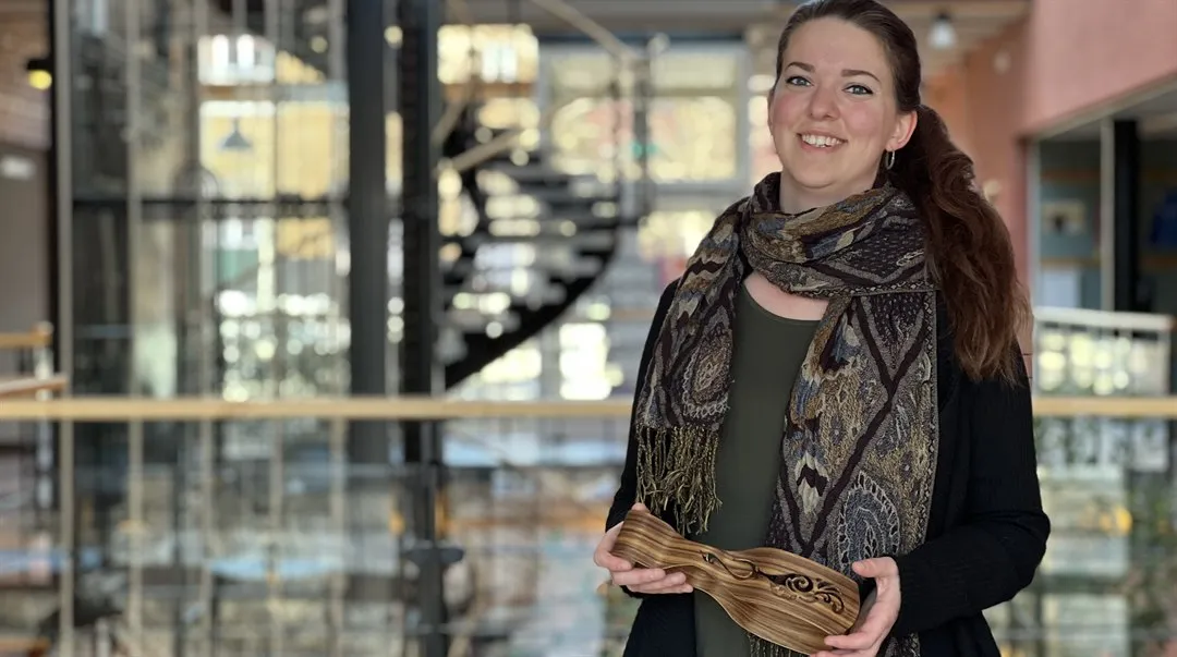 En kvinna hållandes i ett salladsbestick gjort av trä