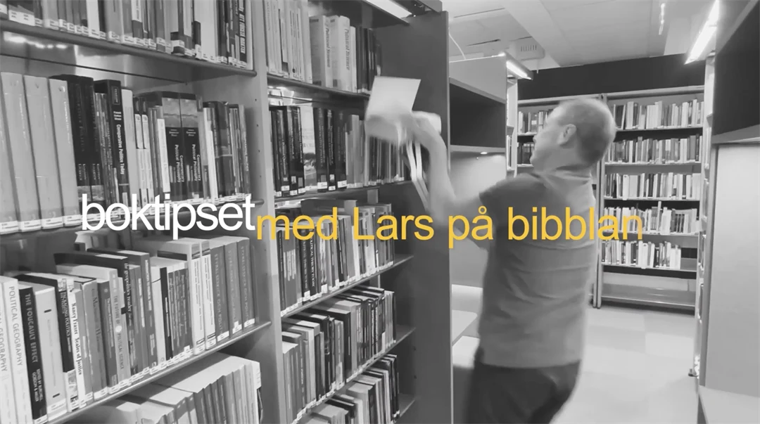 man i bibliotek som kämpar att hålla i flera böcker