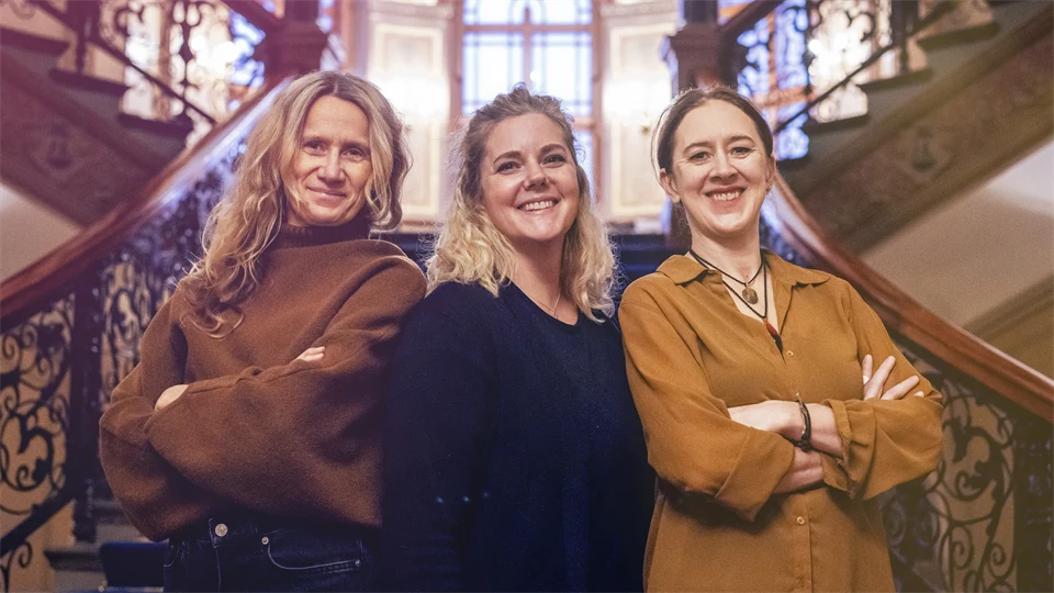 Tre kvinnor framför en trappa