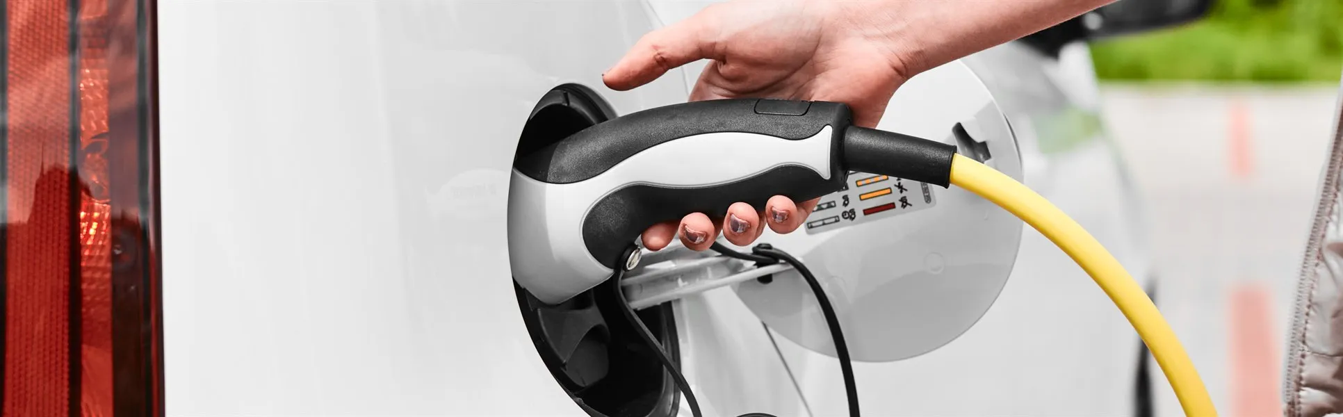 kvinna kopplar ur en laddare från elbil