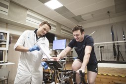 Seb Ison cyklar på en testcykel övervakad av testledare Hampus Lindblom.