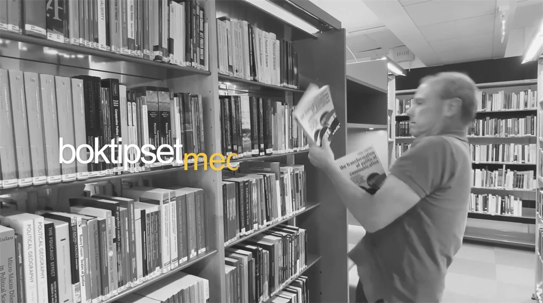 man i bibliotek som kämpar att hålla i flera böcker