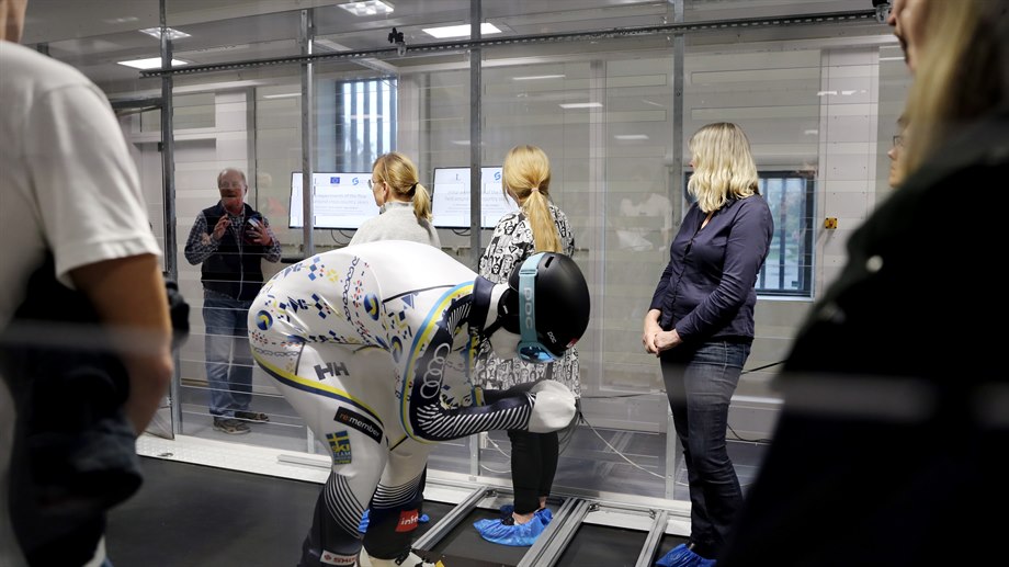 En modell av en alpinåkare i trä visas i vindtunneln..