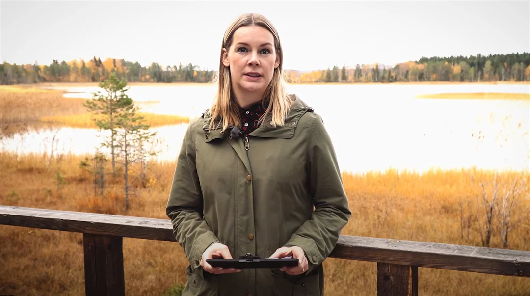 En tjej står vid en sjö