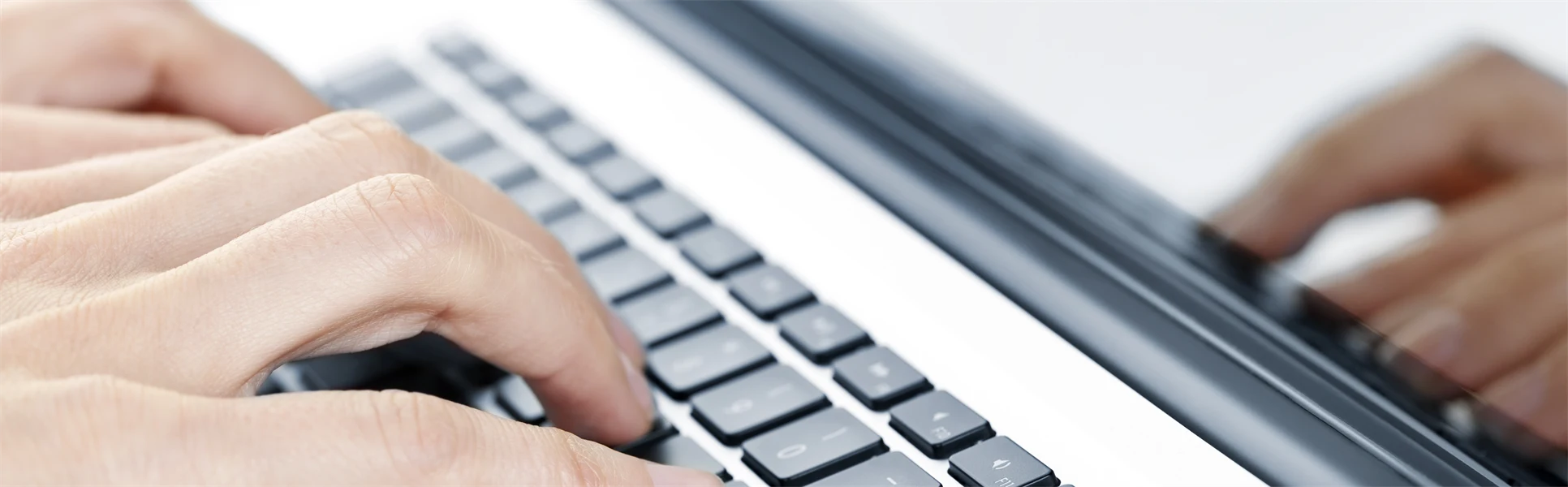 Hands typing on laptop keyboard