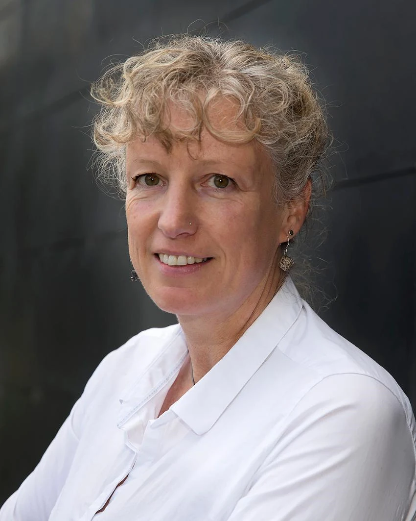 En kvinna i ljust hår i en vit skjorta