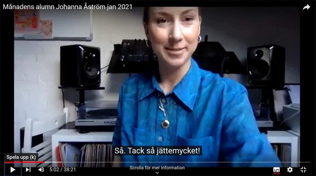 Kvinna i blå skjorta tittar in i kameran.