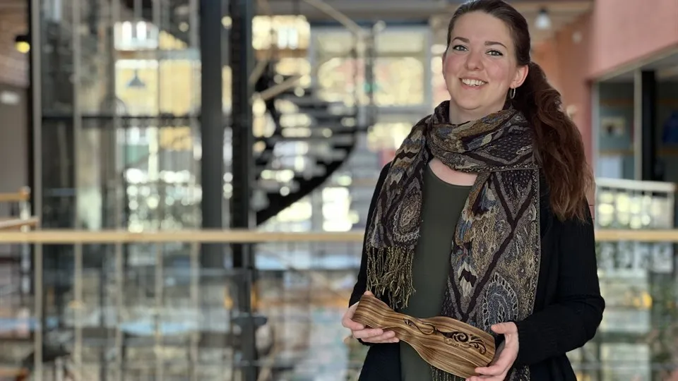 En kvinna hållandes i ett salladsbestick gjort av trä