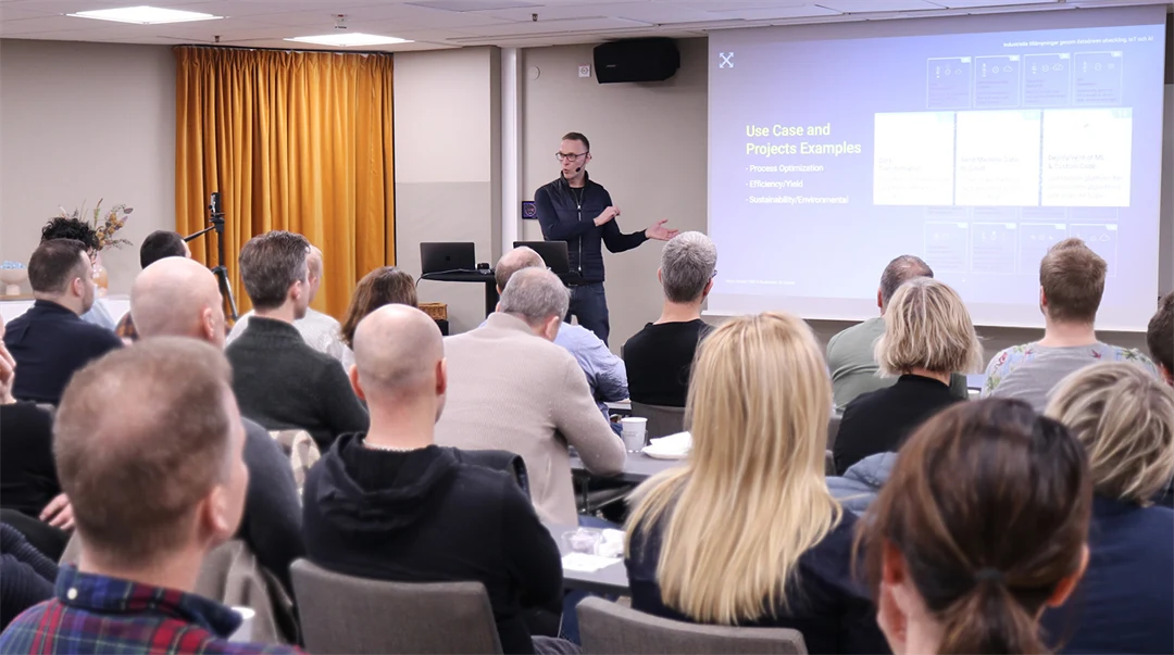 A man stands in front of an audience and speaks.