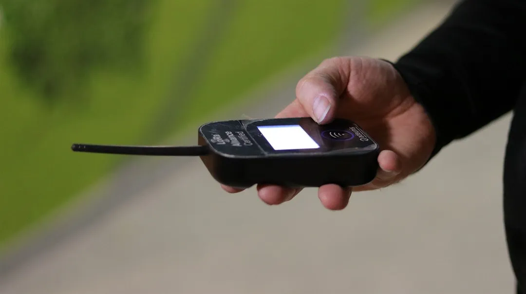 En hand håller i en signalmottagare.