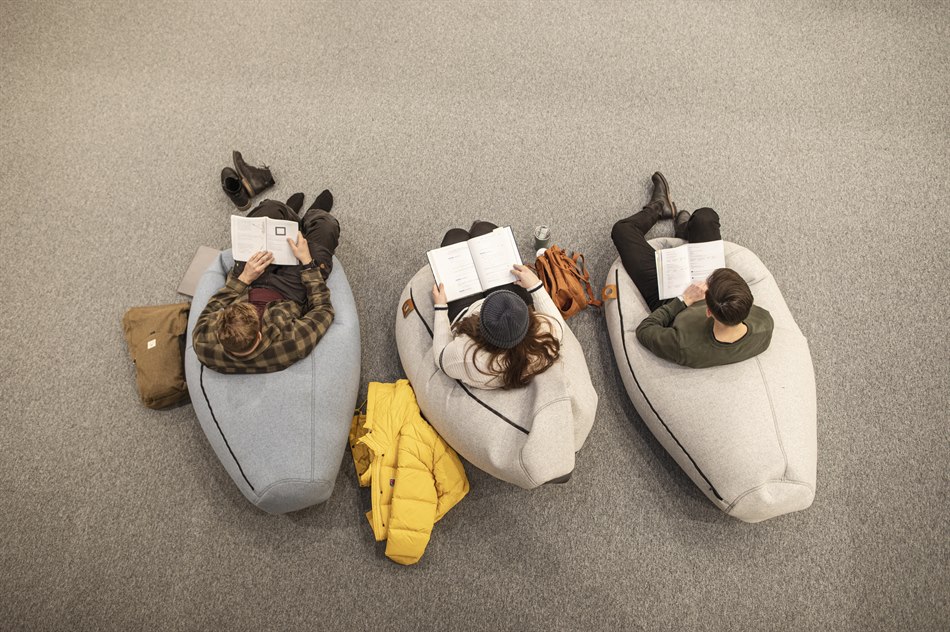 Läser bok sittande i mysiga säckar