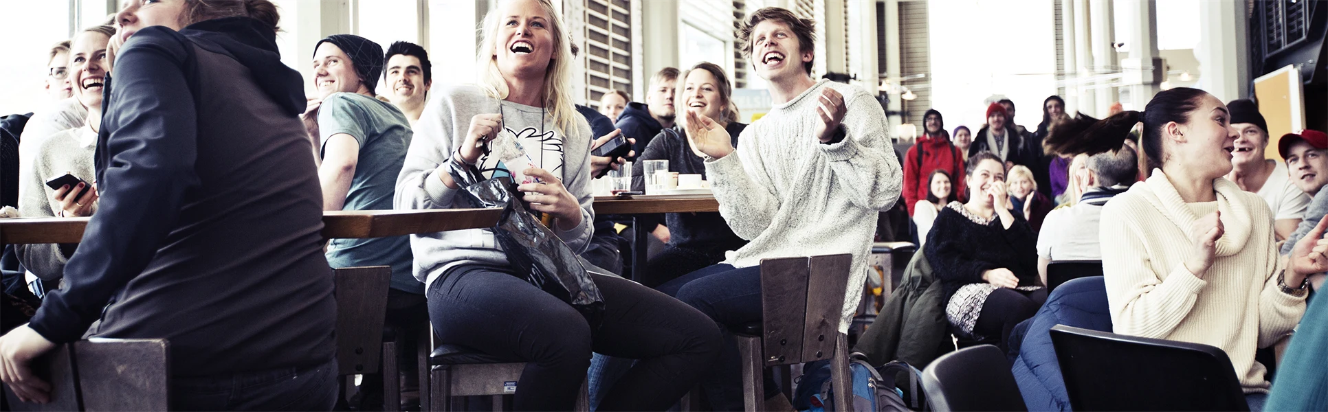 Studenter i Ljushallen som tittar på skidåkning. 