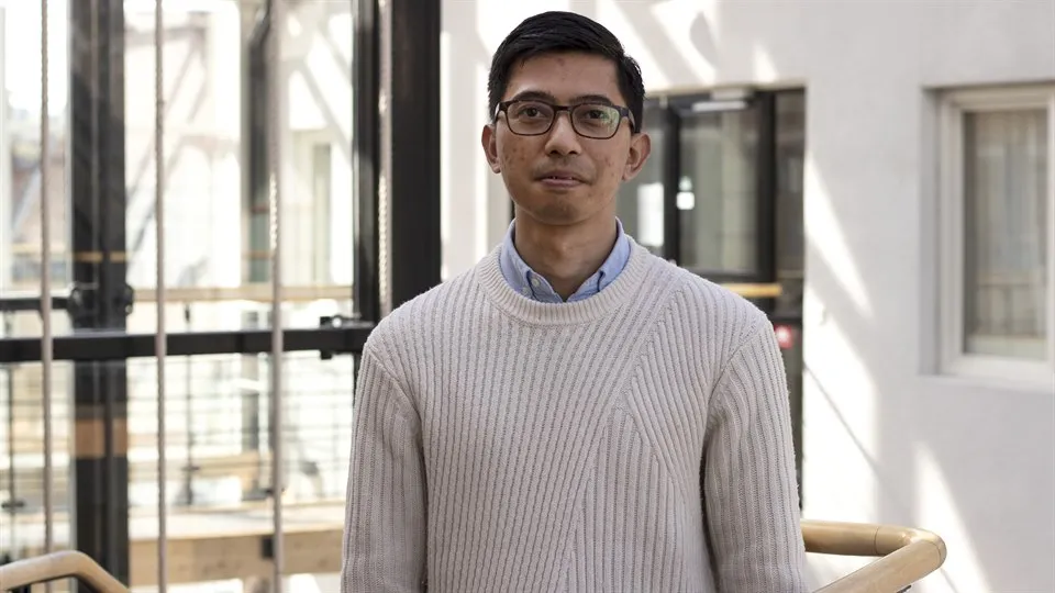 Man med glasögon och mörkt hår poserar för kameran.