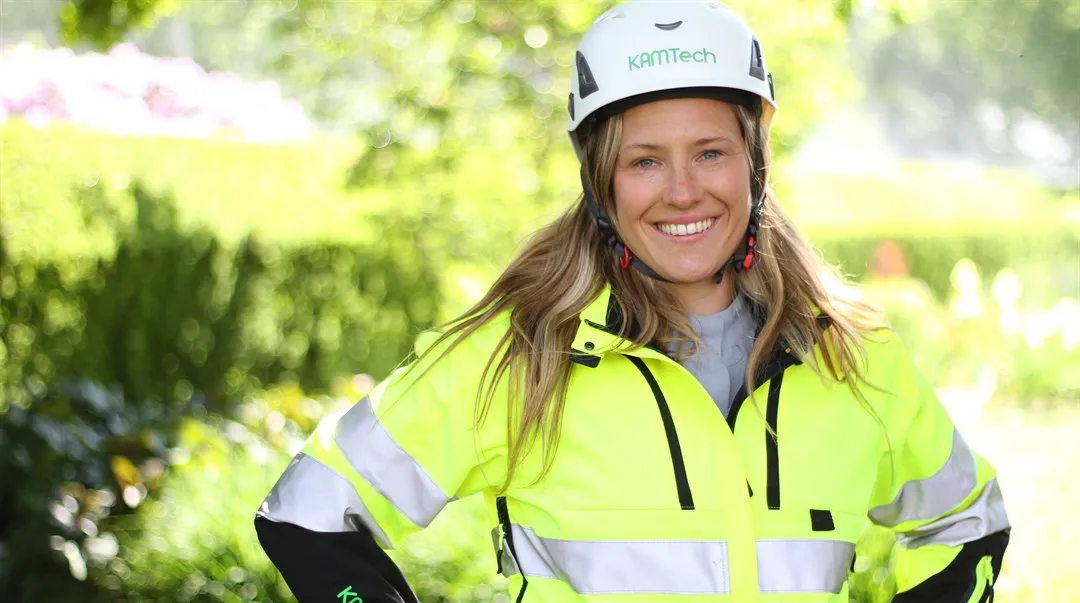 Porträttbild av student utomhus med arbetskläder