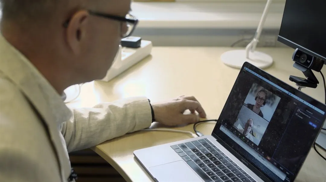 Man i ett digitalt möte genom en dator.