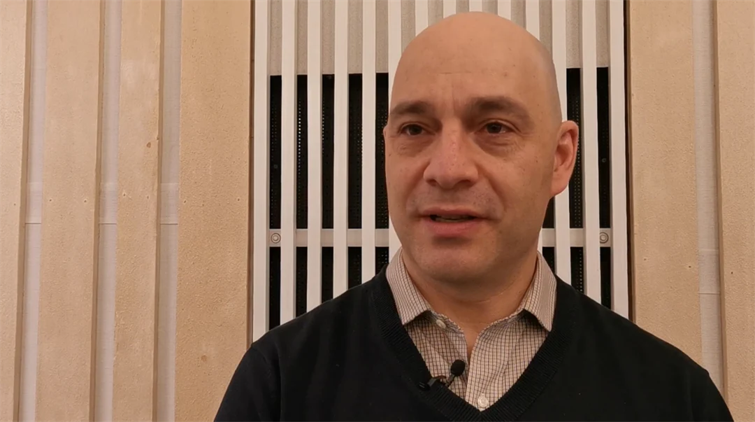 Man med skjorta och svart tröja intervjuas