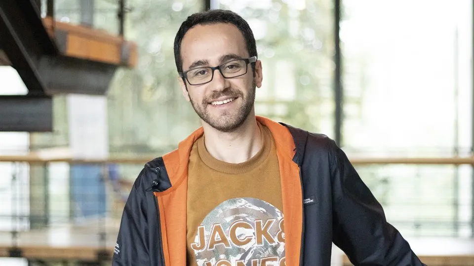 En man i glasögon poserar framför kameran.