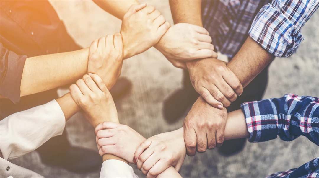 Åtta händer som håller i nästa handled så det bildas en trygg ring.